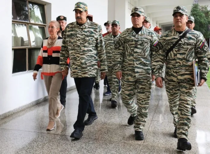 Nicolás Maduro (2.º-izquierda), caminando con su esposa, Cilia Flores, y el ministro de Defensa de Venezuela, Vladimir Padrino (2.º-derecha), antes de una reunión con el alto mando militar en Caracas. AFP